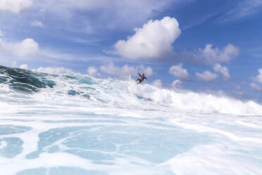 Surfer auf einer blauen Welle an einem sonnigen Tag - CAVF95198