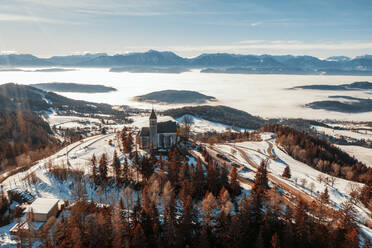 Gebaute Struktur inmitten von Bäumen auf Schnee am Magdalensberg, Klagenfurt, Kärnten, Österreich - DAWF02237