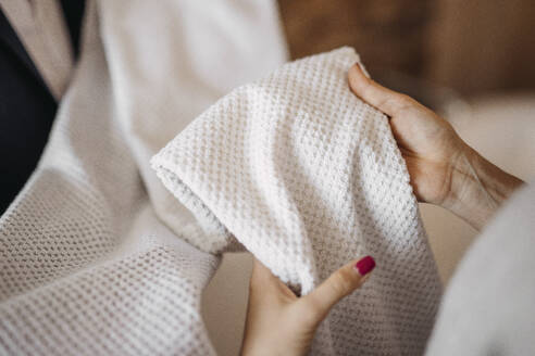 Woman checking fabric of clothes in shop - DAWF02267