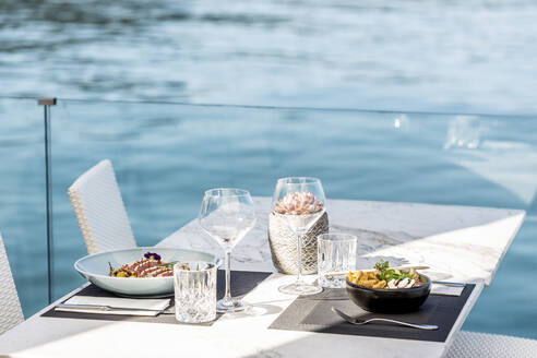 Asiatisches Essen und Thunfisch auf dem Tisch am Wasser serviert - DAWF02282