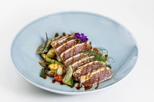 Tuna steaks in bowl on white background - DAWF02283