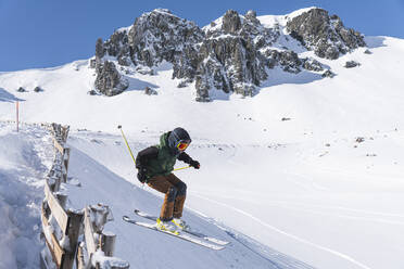 Junger Tourist beim Skifahren auf einem schneebedeckten Berg - JAQF00904