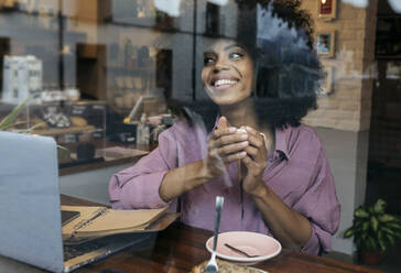Lächelnder Freiberufler mit Kaffeetasse und Blick aus dem Fenster - JCCMF04552