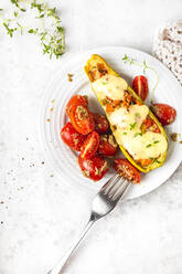 Frische gefüllte Zucchini mit Kirschtomaten und Käse im Teller - FLMF00686