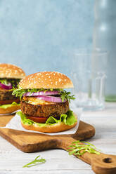 Vegetarian burger sandwiches on cutting board - FLMF00713