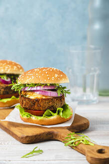 Vegetarian burger sandwiches on cutting board - FLMF00713