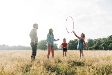 Familie spielt mit Hula-Hoop-Reifen im Park am Wochenende - ASGF01727