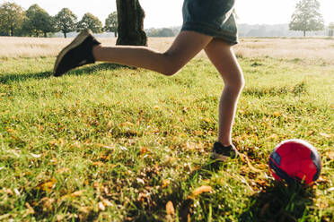 Girl playing with ball in park on sunny day - ASGF01750