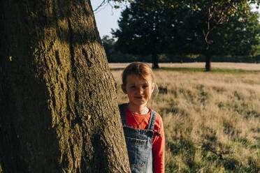 Nettes Mädchen steht bei einem Baum im Park - ASGF01772