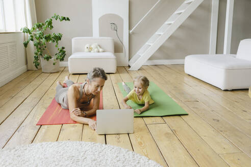 Mutter und Tochter lernen Yoga zu Hause am Laptop - SEAF00091