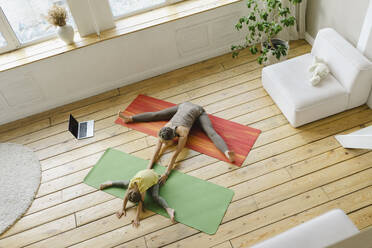 Familie übt gemeinsam Yoga-Pose im Wohnzimmer - SEAF00101