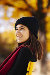 Lächelndes jugendliches Mädchen mit Schal und warmer Kleidung - DAWF02307