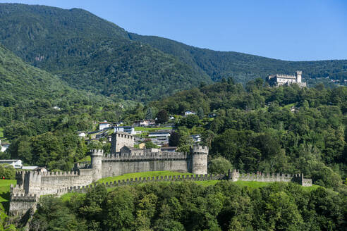 Schweiz, Tessin, Bellinzona, Schloss Montebello mit grünen bewaldeten Bergen im Hintergrund - RUNF04667