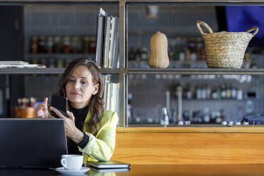 Geschäftsfrau mit Laptop und Smartphone in einem Café - IFRF01234