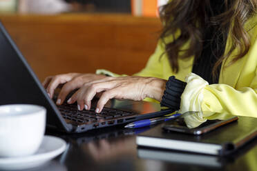 Geschäftsfrau mit Laptop am Tisch in einem Cafe - IFRF01237