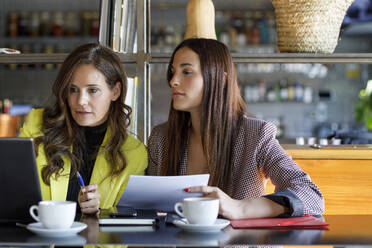 Businesswomen with laptop working together at cafe - IFRF01238