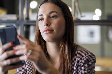 Freelancer using smart phone in coffee shop - IFRF01250