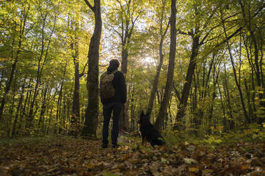 Junger Mann mit Hund beim Wandern im Wald - SSGF00269