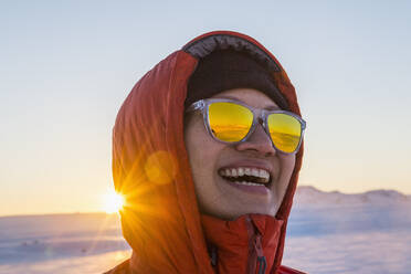 Porträt einer lachenden Frau vor dem Hintergrund des arktischen Sonnenaufgangs - CAVF95239