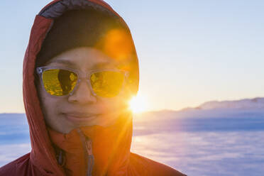Porträt einer lächelnden Frau vor dem Hintergrund des arktischen Sonnenaufgangs - CAVF95240