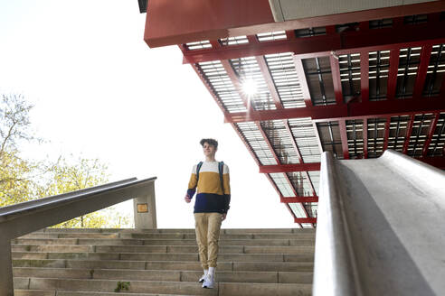 Schülerin mit Rucksack geht Treppe hinunter im Freien - CAVF95275