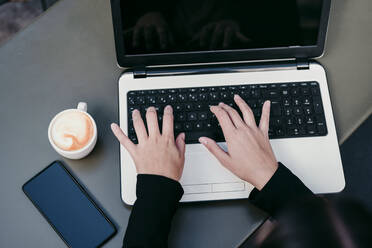 Businesswoman using laptop at cafe table - EBBF04834