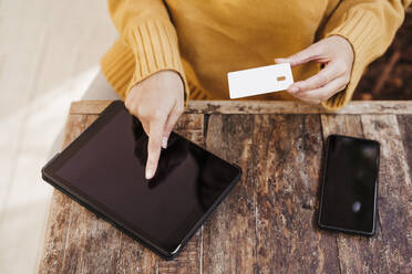 Frau beim Online-Einkauf über ein digitales Tablet auf dem Tisch eines Cafés - EBBF04855