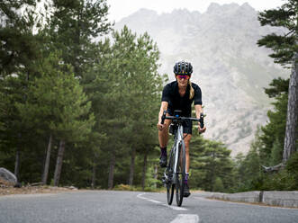 Sportlerin mit Helm beim Radfahren auf der Straße - MALF00367