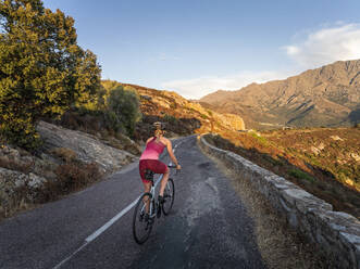 Athlete riding mountain bike on road - MALF00370