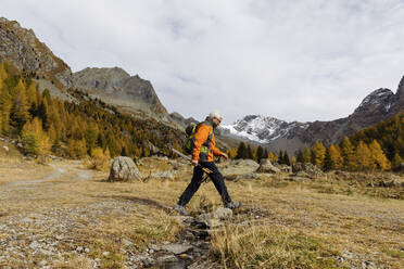 Mann mit Rucksack beim Wandern auf einem Berg - MRAF00762