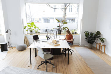 Young businesswoman working at office desk - FKF04554