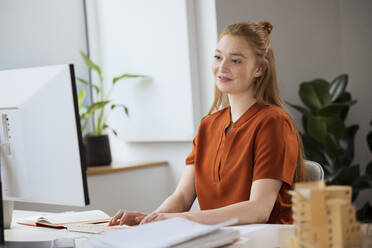 Young businesswoman using computer in office - FKF04556