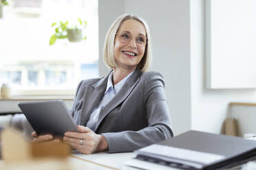 Businesswoman with tablet PC at workplace - FKF04572