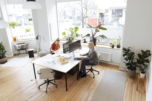 Geschäftsfrauen bei der Arbeit am Bürotisch - FKF04590