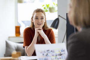 Businesswoman discussing with colleague in office - FKF04593