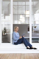 Geschäftsfrau mit Tablet-PC am Büroeingang - FKF04608