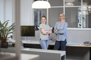 Confident businesswomen with arms crossed at office - FKF04626