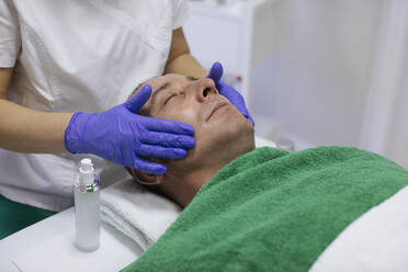 Mann erhält Gesichtsbehandlung im Schönheitssalon - MOMF00952