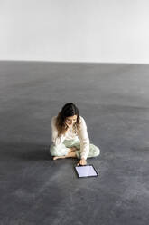 Young businesswoman working on tablet pc in industrial hall - PESF03260