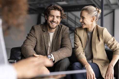 Smiling businessman and colleague discussing in industrial hall - PESF03274