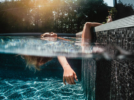 6 Jahre altes Mädchen entspannt und badet in einem Schwimmbad - CAVF95366