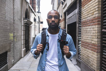 Mann mit Rucksack in Gasse stehend - ASGF01791