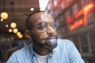 Man with eyeglasses day dreaming in cafe - ASGF01799