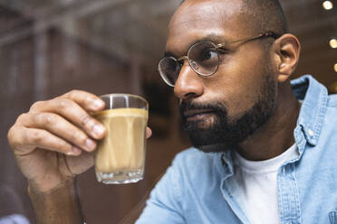 Nachdenklicher Mann trinkt Kaffee im Cafe - ASGF01800