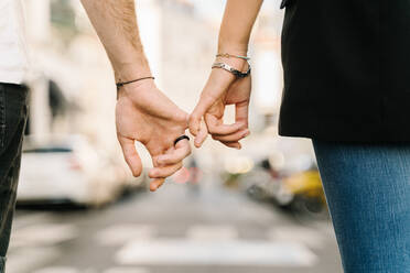 Rückansicht der Ernte unerkennbar romantisches Paar hält kleine Finger beim Gehen auf der Straße auf sonnigen Tag in der Stadt - ADSF31793