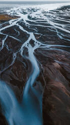 Malerische Luftaufnahme von kurvenreichen Flüssen, die durch wildes Bergland in Island fließen - ADSF31797