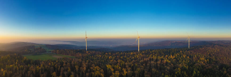 Aerial panorama of wind farm in forested Schurwald range at dusk - WDF06674