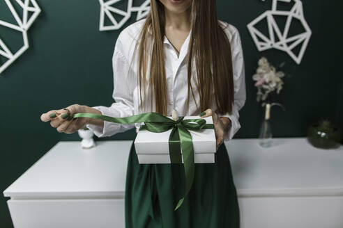 Saleswoman opening gift box in office - LLUF00398