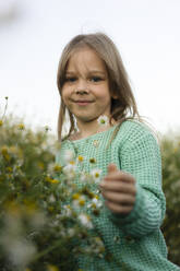 Lächelndes Mädchen bei Blumen auf einer Wiese stehend - SSGF00295