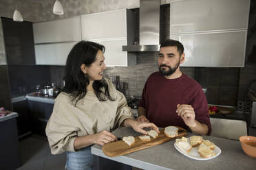 Couple preparing breakfast in kitchen - LLUF00411
